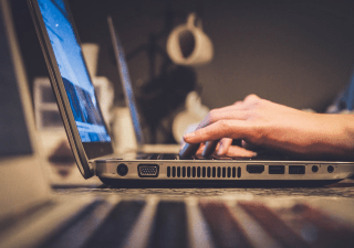 Hands typing on a laptop.